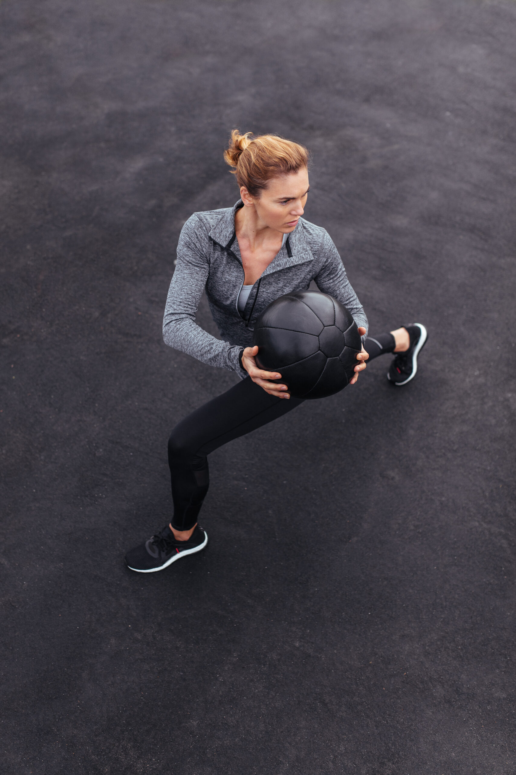 Fit and strong female working out with a medicine ball. Woman doing crossfit workout out